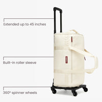 Beige rolling suitcase with extended handle and built-in roller sleeve on a white background.