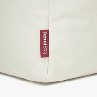 Close-up of a beige bag with a red label.