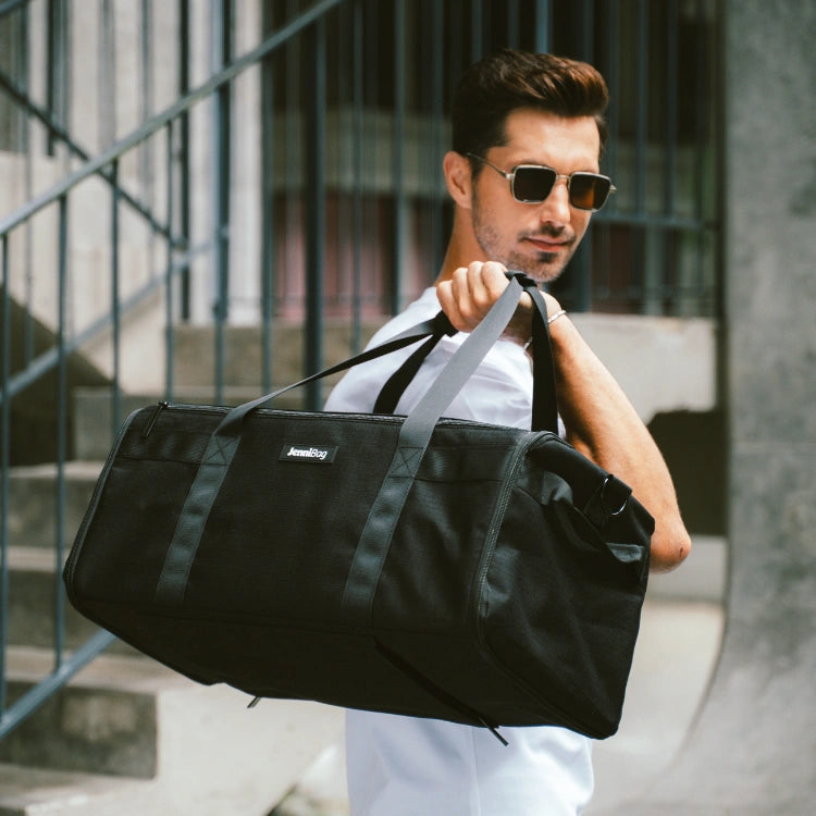 Man carrying a black Original Carry-on as a duffel by its handles